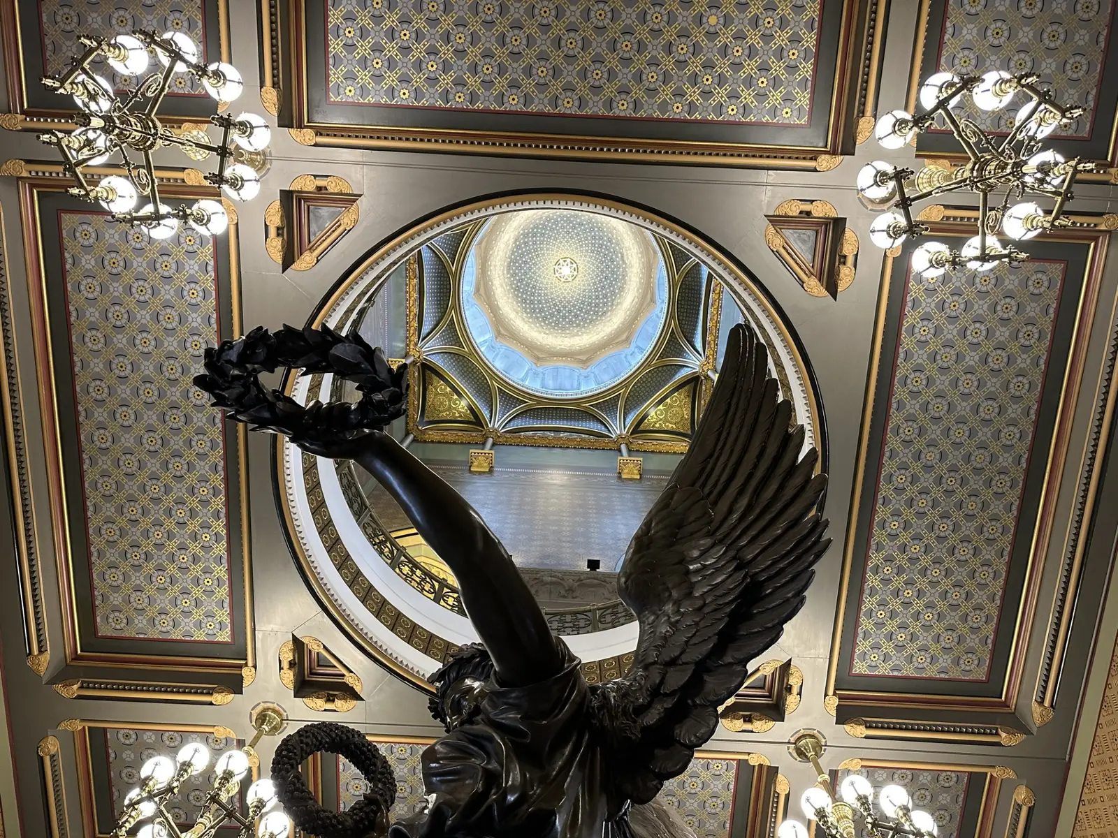 The ornate gilded ceiling and Genius of Connecticut statue inside the State Capitol rotunda